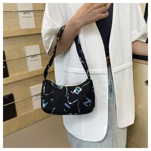 Detail of artistic graffiti print on black nylon shoulder bag with abstract lettering