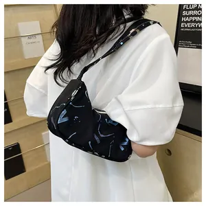 Detail of black canvas hobo bag featuring blue abstract prints and single shoulder strap