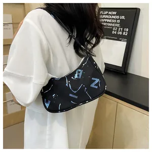 Detailed back view of a black canvas baguette bag with blue letter print and shoulder strap