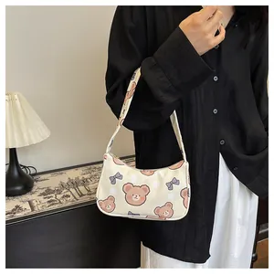 Dettaglio della borsa hobo con simpatica stampa di orso e fiocco blu su tessuto crema