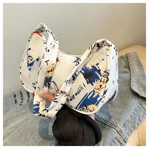 Detail of white underarm bag featuring artistic blue and black graffiti prints on fabric