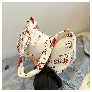 Detail of white graffiti underarm bag with red and blue lettering and metal zipper
