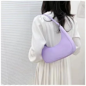Rear view of a lavender hobo bag worn by a model against a white wall with blinds