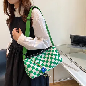 Green and white checkerboard cylindrical canvas crossbody bag with adjustable strap