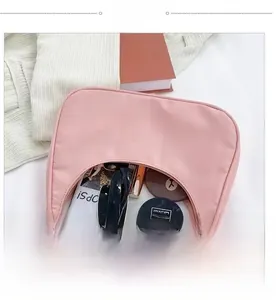 Internal view of pink crescent hobo bag showing capacity for cosmetics and sunglasses