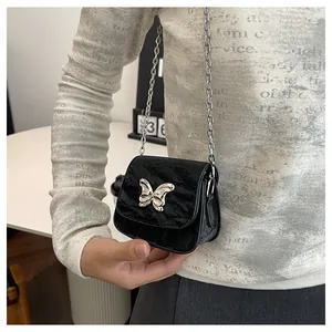 Close-up of black crinkled mini crossbody bag with a silver butterfly bow detail