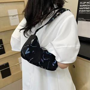 Minimalist black underarm bag with blue abstract prints and stylish wide shoulder strap