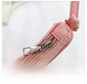 Close-up of the durable silver metal zipper on a pink fabric baguette shoulder bag