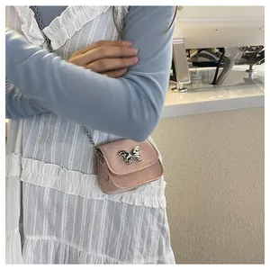 Detail of light pink leather mini bag with silver butterfly clasp and metal chain strap