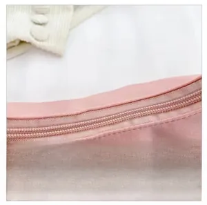 Close-up of smooth pink metal zipper on a minimalist crescent underarm bag fabric