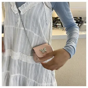 Pink mini crossbody bag with silver butterfly buckle and delicate chain strap details