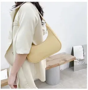 Detail of minimalist pale yellow crescent shoulder bag with smooth leather and zipper