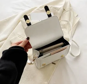 Close-up of internal storage of white PU crossbody bag with phone and notepad