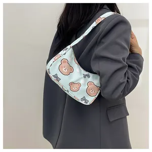 Dettaglio borsa sottobraccio azzurra con simpatici orsetti e motivi a fiocco chic