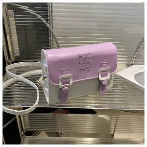 Detail view of the cat embroidery and gold hardware on this purple crossbody bag