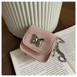 Close-up of pink mini crossbody bag with silver butterfly clasp and metal chain strap