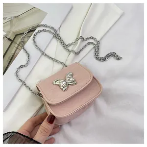 Detailed view of pink mini crossbody bag with crocodile texture and silver butterfly clasp
