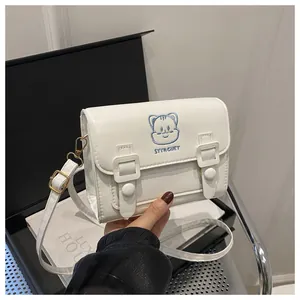 Close-up of cute cartoon embroidery on white PU leather crossbody bag with flap