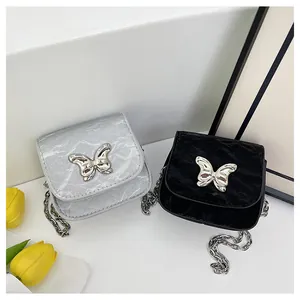 Close-up of silver and black mini bow bags with metallic chain and crinkle texture