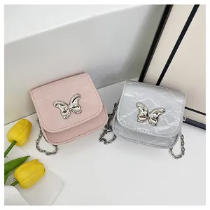 Detail of mini bow crossbody bags with silver metal butterfly clasp and chain straps