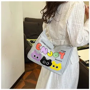Borsa a tracolla in tela grigia con scritte Enjoy e stampa gatto mostrata su modella