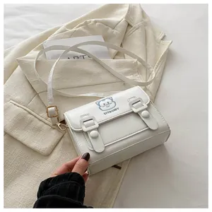 Detail of white PU crossbody bag with cartoon cat pattern and gold hardware