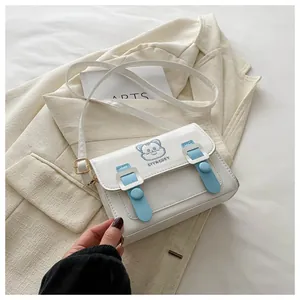 Detailed close-up of a white and blue PU leather satchel with cute cartoon cat embroidery