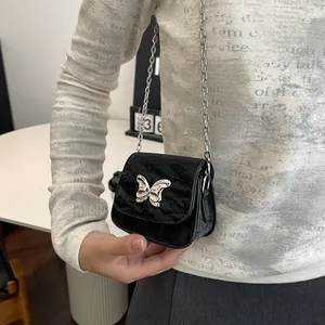 Chic black mini crossbody bag with silver butterfly buckle and metallic chain strap