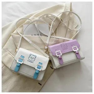 Detail of cute cartoon cat crossbody bags in white blue and white purple colors