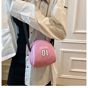 Detail of pink canvas shell bag with CHINA 01 print worn by model on shoulder