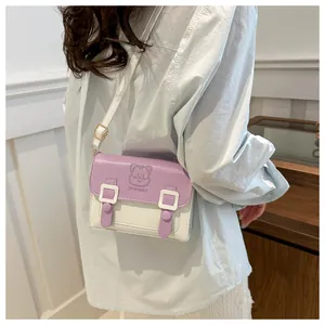 Detail of lavender and cream crossbody bag featuring a cute cat embossed pattern