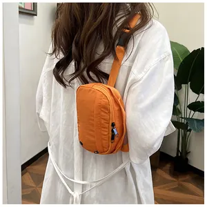 Close-up of orange nylon crossbody bag shown on model's back with vibrant textures