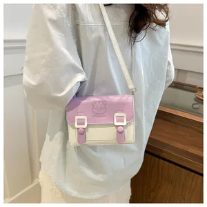 Detail of the lavender and off-white messenger bag with a cute cartoon embossed pattern
