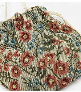 Detailed view of jacquard canvas drawstring bag with vintage red and blue floral patterns