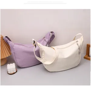 Detail of waffle textured crescent bags in purple and cream with metal rabbit charm