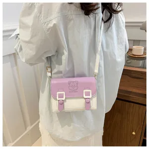 Detail of cute cartoon cat crossbody bag in lilac and cream colors on a model