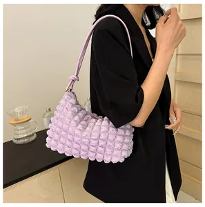 Detail of light purple pleated shoulder bag with bubble texture and stylish knot strap