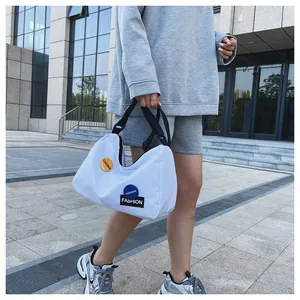 Detalle del bolso de lona blanca con parches de moda y emblema naranja de estilo casual