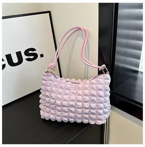 Close-up of lavender pleated bag with bubble texture and golden ring hardware details