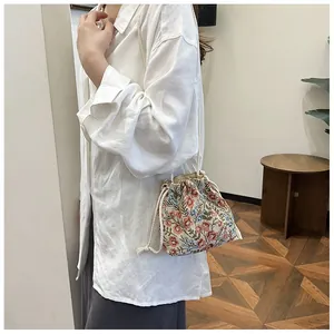 Close-up of floral jacquard canvas bucket bag with drawstring closure and braided strap
