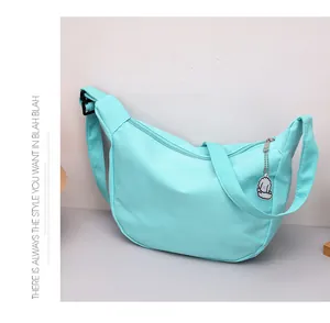 Detailed view of light blue waffle texture hobo bag with adjustable strap and puppy charm