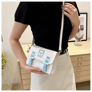 White PU leather cartoon cat crossbody bag shown on a model in a cozy home setting