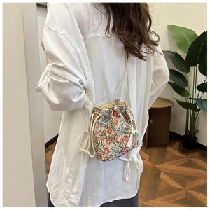 Detail of floral drawstring bucket bag with a crossbody strap and retro floral pattern