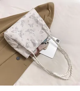 Top view of spacious white tote bag interior with silver butterfly print and woven straps