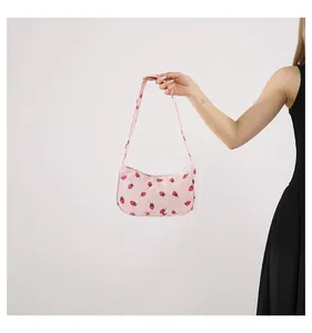 Detailopname van roze corduroy baguette tas met aardbeienprint en zachte textuur
