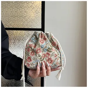 Detail of floral brocade drawstring bucket bag featuring blue and pink flower patterns
