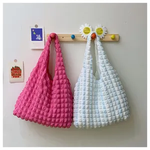 Detailed macro view of bubble pleated handbags in rose red and blue-white stripes
