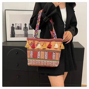 Ethnic embroidered tote bag detail with colorful tassels and woven shoulder strap