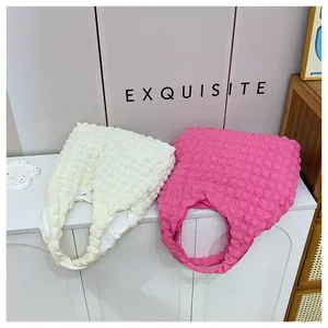 Detailed view of the 3D popcorn texture on cream and pink pleated shoulder bags