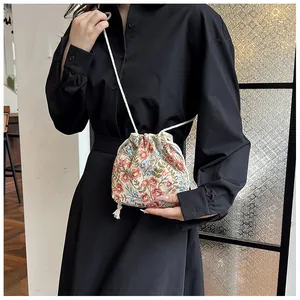 Detail of floral drawstring bucket bag with jacquard fabric and tassel decoration